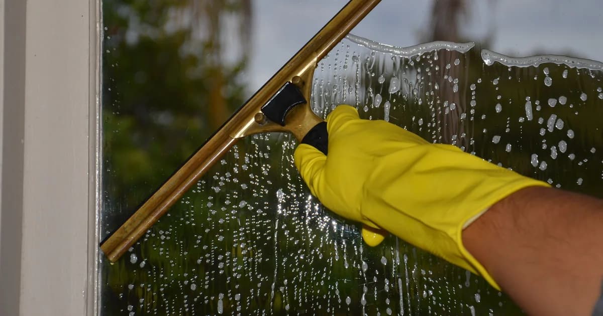 Squeegee drawn across a soapy window pane during an exterior window clean